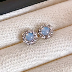 Vue macro des boucles d'oreilles tournesol en argent avec opale bleue et zircons