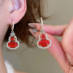 Detail of 14k gold plated gourd drop earring with red gemstones and sparkling zircon accents