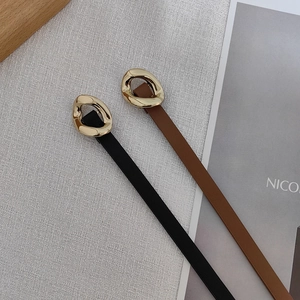 Flat lay of narrow black and brown leather belts with irregular gold metal buckles