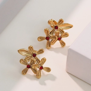 Elegant gold three-flower stud earrings with deep red crystals in a layered floral design