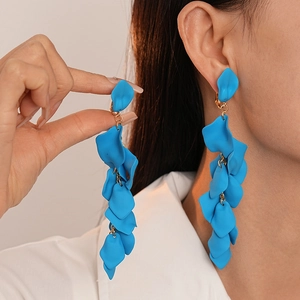 Long blue wrinkled acrylic petal tassel clip earrings shown on a model neck side view