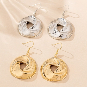 Detailed view of twisted round metal hoop earrings in gold and silver finishes