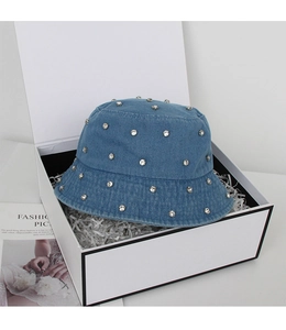 Detail of blue washed denim bucket hat with rhinestones inside a white gift box
