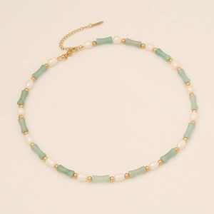 Detail of bamboo joint natural stone necklace with irregular pearls and gold hardware