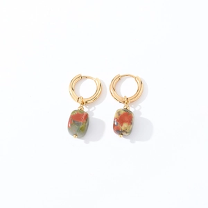 Close-up of gold geometric drop earrings with polished green and red natural stones