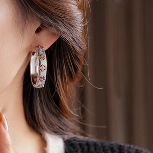 Gros plan d'une femme portant des boucles d'oreilles créoles avec fleurs en zircon