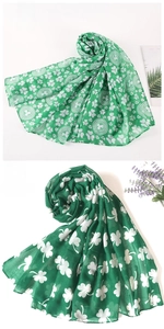 Detail shot of green St. Patrick's Day scarf with white clover patterns and sheer fabric