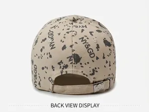 Vue arrière d'une casquette beige élégante avec imprimé de lettres et taches noires