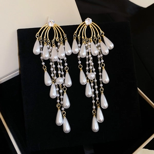 Detail of vintage French style gold tassel earrings with teardrop pearls and crystals