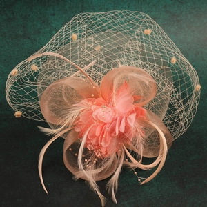 Macro detail of peach bridal fascinator with mesh veil, feathers, and floral accents
