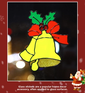 Detail of Christmas glass window sticker featuring glittery red bells and green holly leaves