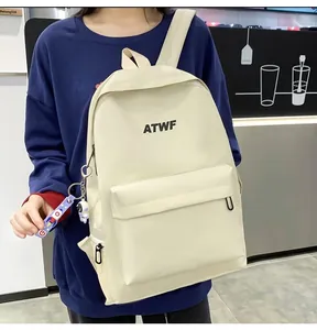 Detail view of large capacity white backpack with ATWF logo and astronaut charm decoration