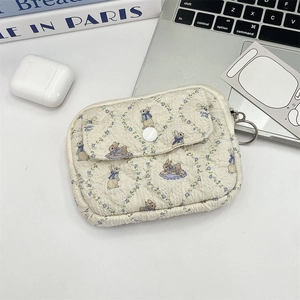 Detailed view of beige quilted floral pouch with cute rabbit print and metal keychain