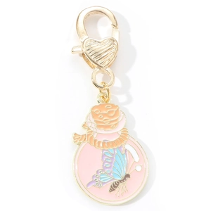 Detail of gold-plated butterfly charm with pink enamel and heart-shaped lobster clasp