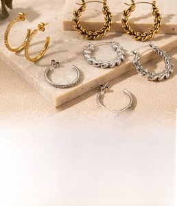 Détail macro de boucles d'oreilles en C dorées avec motif épi de blé et zircons micro-sertis