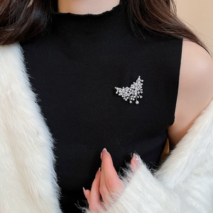 Detail of elegant butterfly pearl brooch with sparkling zircons on a white faux fur coat