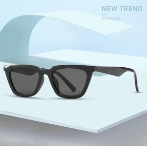 Close-up of black thick frame sunglasses with dark grey lenses on a minimalist blue stand