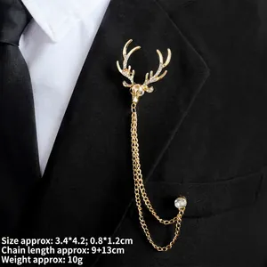 Close-up of a golden deer head brooch with rhinestones and tassel chains on a black suit