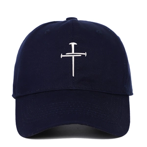 Detailed close-up of nail cross embroidery on navy blue cotton baseball cap