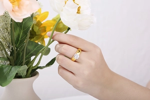 Detail of 6mm round zircon solitaire engagement ring in gold finish on female hand
