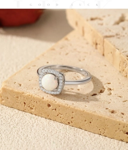 Close-up of S925 silver ring featuring a round opal stone in a square halo setting