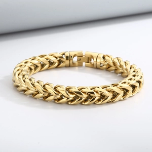 Macro view of golden wheat chain link bracelet with polished metal finish and sturdy clasp