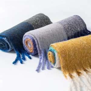 Close-up of three soft mohair plaid scarves in blue, purple and yellow with fringe