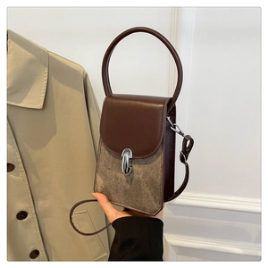 Detail of vintage crossbody bag in dark brown leather and beige canvas with metal buckle
