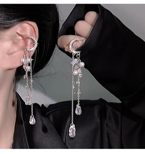 Close-up of silver crescent moon tassel earring with pearls and sparkling crystals
