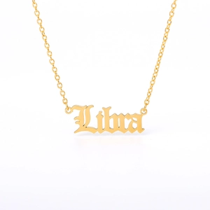 Detail view of the Libra pendant necklace in polished gold with Gothic lettering