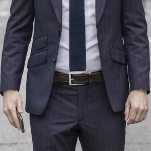 Men's dark brown leather belt with silver pin buckle worn with blue striped business suit