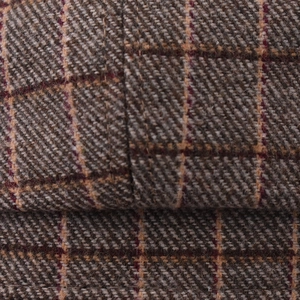 Macro view of brown plaid octagonal cap showing wool blend fabric texture and stitching