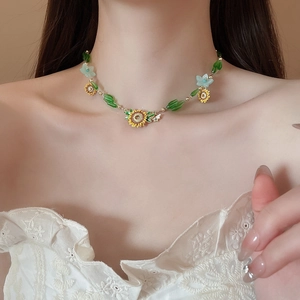 Model wearing sunflower bee necklace with yellow petals and green beaded floral details
