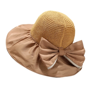 Women's khaki straw sun hat with large bow and wide brim for UV protection