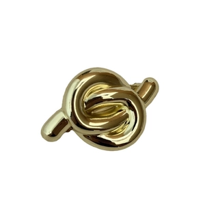Elegant gold metal twist lock accessory for bags with a glossy finish on white background