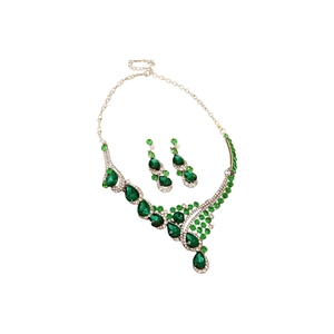 Vintage jewelry set with green teardrop stones and silver crystals on white background