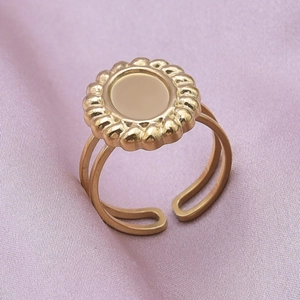 Detail of a gold sunflower ring with double-layered open band on purple silk fabric