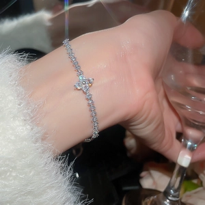 Close-up of elegant silver flower bracelet with zircon pavé worn during a cocktail party