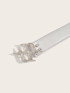 Macro detail of silver belt buckle with sparkling rhinestones and metal rivets