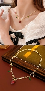 Close-up of strawberry glass pendant and beaded chain necklace shown on model and wood