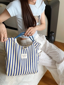 Striped seersucker tote bag in blue and yellow with thick woven rope handles