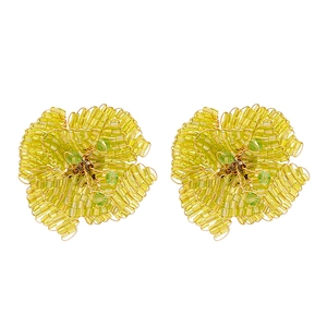 Orecchini a fiore con perline gialle e accenti di vetro verde su uno sfondo bianco