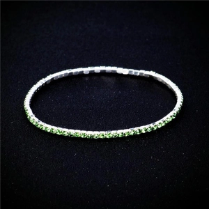Macro shot of 2.0mm ultra-thin stretch bracelet with sparkling green rhinestones on black