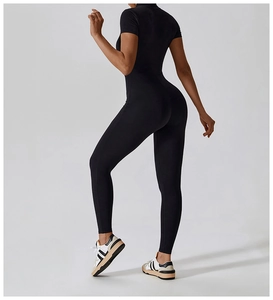 Sleek black short-sleeve yoga unitard showing fitted silhouette and premium matte fabric