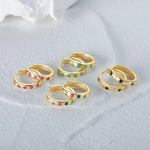 Macro shot of assorted gold sterling silver hoop earrings with multicolored zircons
