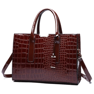 Deep reddish-brown crocodile pattern handbag with glossy finish and top handle on white background
