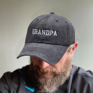 Deep grey washed cotton baseball cap with white GRANDPA embroidery shown on a model