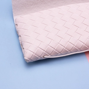 Detail of light pink woven leather glasses case with elastic strap and soft lining