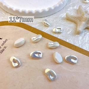 Detail view of 11x7mm baroque irregular pearl nail charms with iridescent finish