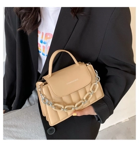 Detail of beige PU leather crossbody bag with mixed metal and acrylic chain strap decoration